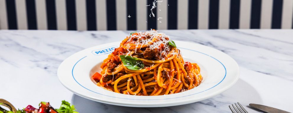 Someone eating pasta and a salad at Prezzo